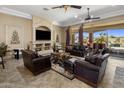 Spacious living room featuring a stone fireplace, leather furniture, and sliding glass doors to the backyard at 18036 W San Miguel Ave, Litchfield Park, AZ 85340