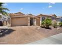 Inviting single-story home with a desert landscape, a tile roof, and a spacious three-car garage at 18242 W Stinson Dr, Surprise, AZ 85374