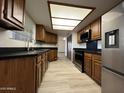 Well-lit kitchen featuring wooden cabinets, black countertops, modern appliances, and a stainless steel refrigerator at 2169 E Bishop Dr, Tempe, AZ 85282