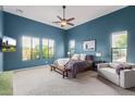 Bright main bedroom with a ceiling fan, carpet, and large windows showcasing stunning backyard and pool views at 2255 N Hillridge --, Mesa, AZ 85207