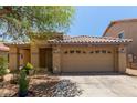 Charming single-story home with a two-car garage, a tile roof, desert landscaping, and security system at 2421 W Romley Rd, Phoenix, AZ 85041