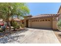 Quaint single-story home featuring desert landscaping, a tile roof, two car garage, and convenient driveway parking at 2421 W Romley Rd, Phoenix, AZ 85041