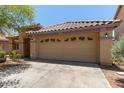 Well-maintained single-story home with a neutral stucco exterior, a tile roof, desert landscaping, and two-car garage at 2421 W Romley Rd, Phoenix, AZ 85041