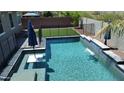 A sparkling pool with a waterfall feature, surrounded by artificial turf and secure fencing for Gathering fun at 31324 N 26 Glen Gln, Phoenix, AZ 85085