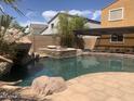 Inviting backyard pool with a rock feature and a hot tub, perfect for outdoor enjoyment at 35743 W Cartegna Ln, Maricopa, AZ 85138