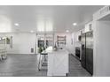 Open floorplan showcasing the white kitchen and stainless steel appliances at 3850 E Ludlow Dr, Phoenix, AZ 85032