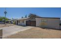 Cozy single-story home with an open driveway and a partially xeriscaped front yard at 4025 E Surrey Ave, Phoenix, AZ 85032