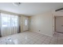 Bright living room with tile floors, a large front window, and neutral paint, ready for personal touches at 4025 E Surrey Ave, Phoenix, AZ 85032