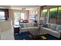 Open-concept living room with elegant furniture, leading to a dining area and outdoor patio at 41318 N Belfair Way, Anthem, AZ 85086