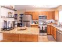 Well-lit kitchen features stainless steel appliances, wood cabinets, and a granite countertop island at 455 S Mesa Dr # 104, Mesa, AZ 85210