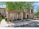 Beautiful home featuring stone exterior, arched entryway, manicured landscaping, and mature tree at 4777 S Fulton Ranch Blvd # 2071, Chandler, AZ 85248