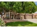 Charming two-story home with a well-manicured lawn, mature tree and a three car garage at 6862 W Honeysuckle Dr, Peoria, AZ 85383