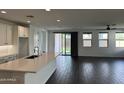 Open-concept living area with hardwood floors, natural light, and modern kitchen island at 6947 W Spur Dr, Peoria, AZ 85383