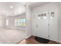Bright entryway with wood floors, white walls, and a sidelight-adorned front door at 1735 E Hope St, Mesa, AZ 85203