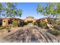 Stately home with desert landscaping, circular entryway and three-car garages offers elegant curb appeal at 18127 N 98Th Way, Scottsdale, AZ 85255