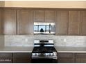 Kitchen showcasing granite countertops, stainless steel appliances and dark wood cabinets at 18162 W Larkspur Dr, Goodyear, AZ 85338