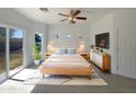 Cozy bedroom with sliding glass doors, natural light, and ceiling fan at 19707 N Pepka Ct, Maricopa, AZ 85138