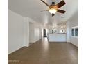 Spacious living room with sleek tile flooring leading to the kitchen at 19707 N Pepka Ct, Maricopa, AZ 85138