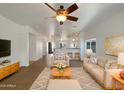 Bright living room features modern decor, a ceiling fan and an open floor plan at 19707 N Pepka Ct, Maricopa, AZ 85138