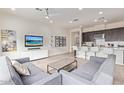Comfortable living room featuring stylish furnishings, a flat-screen TV, and a view into the modern kitchen at 23386 N 73Rd Way, Scottsdale, AZ 85255