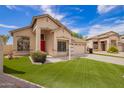 This home features a well-maintained lawn, desert landscaping, and a bright red front door at 2602 E Glass Ln, Phoenix, AZ 85042