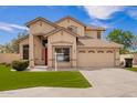 Front exterior showcases desert landscaping and two car garage of this charming tan two-story home at 2602 E Glass Ln, Phoenix, AZ 85042