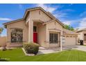 The front of this beautiful home boasts desert landscaping, with an inviting bright red front door at 2602 E Glass Ln, Phoenix, AZ 85042