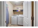 Functional laundry room with washer, dryer, shelving, and ample storage space, conveniently located within the home at 2716 W Sunland Ave, Phoenix, AZ 85041