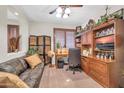 Cozy office space with built-in wooden shelving, desk, and comfortable seating area at 3214 N 138Th Dr, Avondale, AZ 85392