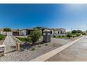 View of the driveway of a modern home with pristine landscaping, artificial grass, and decorative rocks at 3653 E Runaway Bay Pl, Queen Creek, AZ 85142