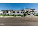 A modern home with a manicured front yard featuring synthetic turf, decorative rocks, and an understated fence at 3653 E Runaway Bay Pl, Queen Creek, AZ 85142