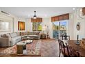 Spacious living room featuring tile flooring, an L-shaped sofa, and a balcony access at 3801 N Goldwater Blvd # 201, Scottsdale, AZ 85251
