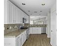 Contemporary kitchen featuring stainless steel appliances, ample white cabinetry, and granite countertops at 41839 W Avella Dr, Maricopa, AZ 85138