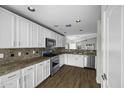 Well-lit kitchen with stainless steel appliances, granite countertops, and white cabinets for a modern feel at 41839 W Avella Dr, Maricopa, AZ 85138