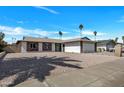 Beautiful home with low maintenance desert landscaping, a two-car garage, and mature palm trees at 4720 W Northview Ave, Glendale, AZ 85301