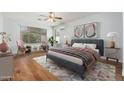 Charming bedroom with wood floors, a ceiling fan, and sitting area with bright natural light at 6180 W Oraibi Dr, Glendale, AZ 85308