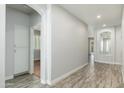 Inviting hallway with wood-style floors, white trim, and neutral paint at 6180 W Oraibi Dr, Glendale, AZ 85308