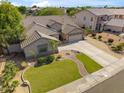 Beautiful single-story home with a well-manicured lawn, mature trees, and a brick-paved walkway at 6827 W El Cortez Pl, Peoria, AZ 85383