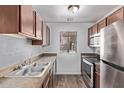 Well-lit kitchen features stainless steel appliances, wood cabinets, and ample counter space, creating a functional cooking area at 747 S Extension Rd # 113, Mesa, AZ 85210