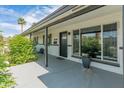Inviting covered front porch with black door and white brickwork, complemented by lush greenery at 7802 E Hubbell St, Scottsdale, AZ 85257