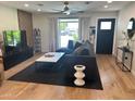 Stylish living room with hardwood floors, a large sectional, and a modern entertainment center at 7802 E Hubbell St, Scottsdale, AZ 85257