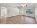 Bright living room featuring tile floors, a ceiling fan, and a front door at 8009 W Salter Dr, Peoria, AZ 85382