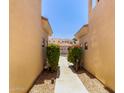 Exterior shot of a walkway between buildings, lined with lush green bushes at 8270 N Hayden Rd # 2041, Scottsdale, AZ 85258