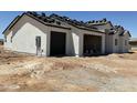 View of new home exterior featuring a two-car garage with roofing being installed at 9429 W Sandstone Mountain Dr, Casa Grande, AZ 85194