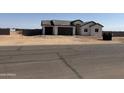 Modern home with three car garage, desert landscaping and a view of the surrounding neighborhood at 9429 W Sandstone Mountain Dr, Casa Grande, AZ 85194