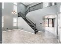 Elegant foyer with a dramatic staircase, soaring ceilings, and neutral colors create a welcoming atmosphere at 9735 W Kirby Ave, Tolleson, AZ 85353