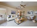Cozy living room featuring neutral furniture, modern decor, a ceiling fan, and an open floor plan at 10722 W Irma Ln, Peoria, AZ 85373