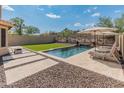 A relaxing pool area with a water feature, artificial turf, and desert landscaping at 12712 W Milton Dr, Peoria, AZ 85383