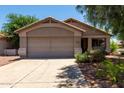 Charming single-story home featuring a two-car garage and desert landscaping at 13861 W Elm St, Surprise, AZ 85374