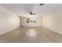 Spacious living room featuring neutral walls, tile flooring, and a ceiling fan for added comfort at 2130 W Colter St, Phoenix, AZ 85015